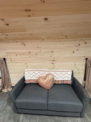 A cozy room with a grey sofa, a decorative heart pillow, and a patterned throw blanket. - Colorful Cape Cod, Lexington / Mansfield / Mid Ohio Sports Car Course - Monthly (Lexington)