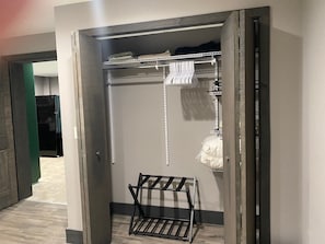 A walk-in closet with a metal rack, shelves, and hanging space. - Colorful Cape Cod (Lexington)