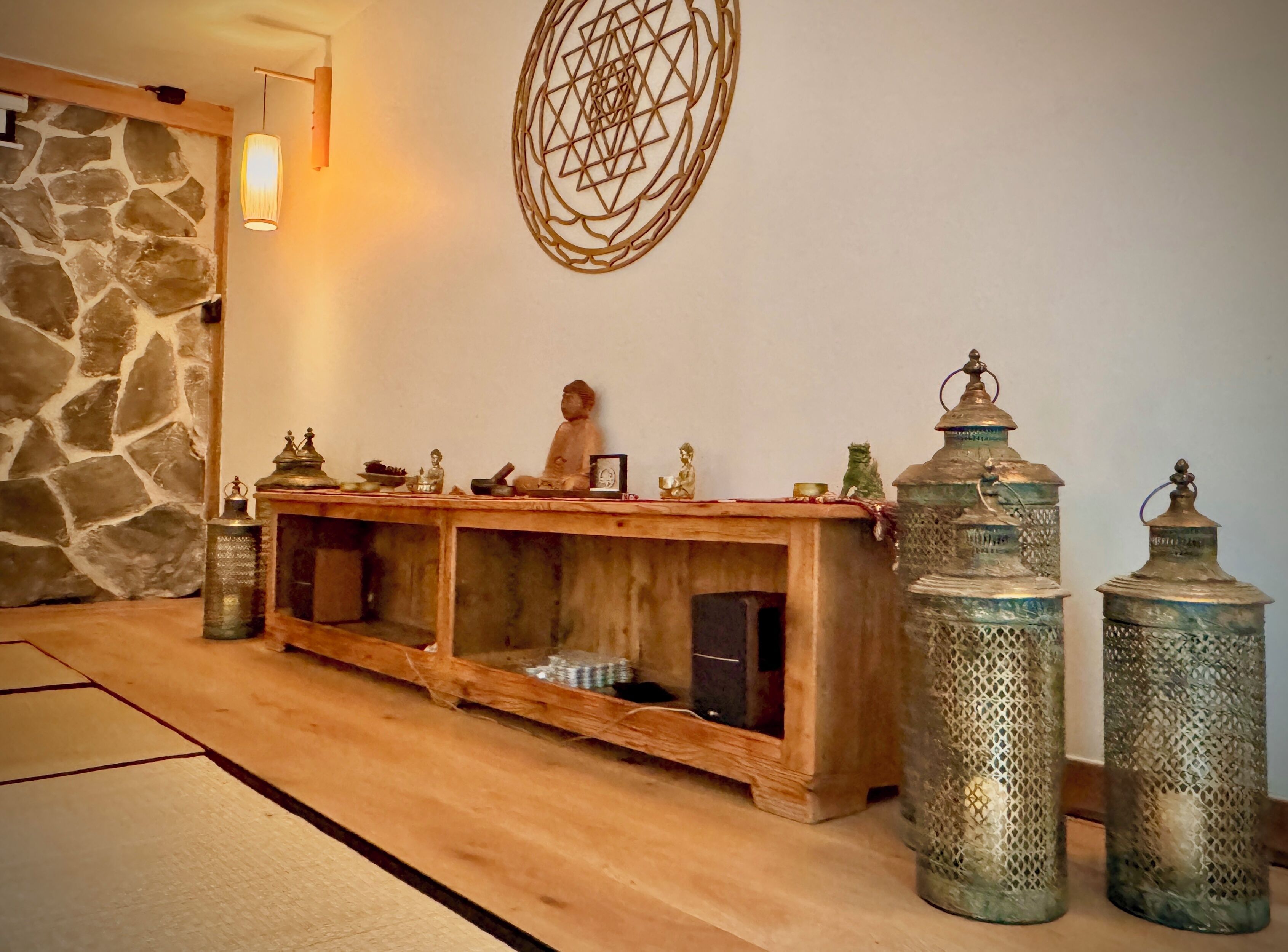 Une console en bois agrémentée d’objets décoratifs et de deux lanternes en métal ouvragé.