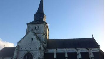 Een kerk met een hoge spits en een brede, gebogen ingang.