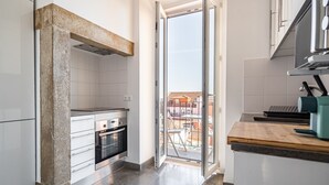 Une cuisine moderne avec des armoires blanches, un four encastré et un plan de travail en bois.