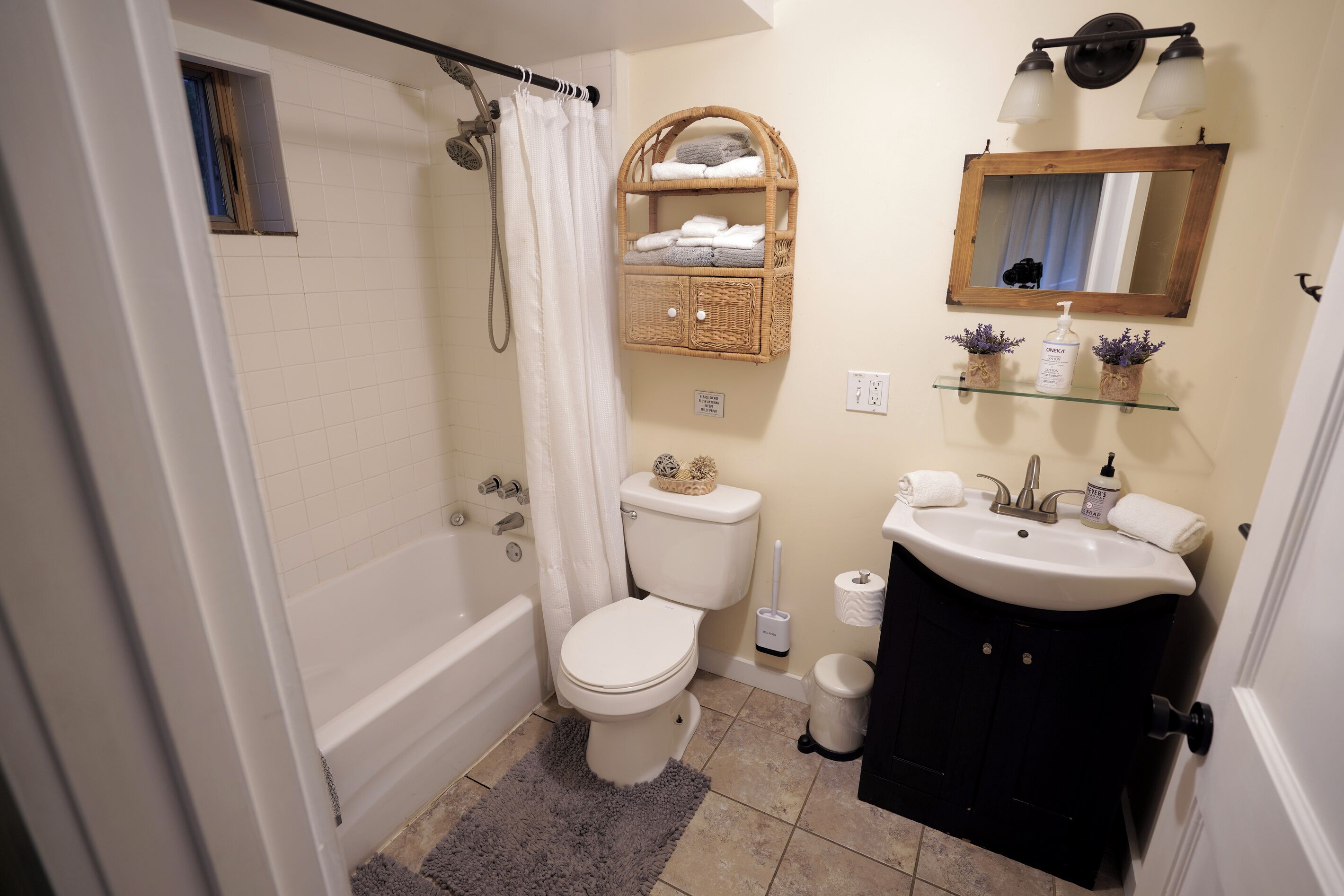 Une salle de bain équipée d’une douche, de toilettes, d’un lavabo et d’un miroir.