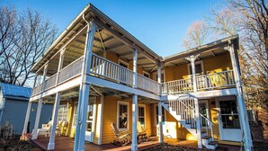 A two-story house with a porch, a staircase, and a small garden area. - Hudson Valley Apartment in a Historic Farmhouse w/ Sauna Near Stone Ridge Hamlet (Stone Ridge)