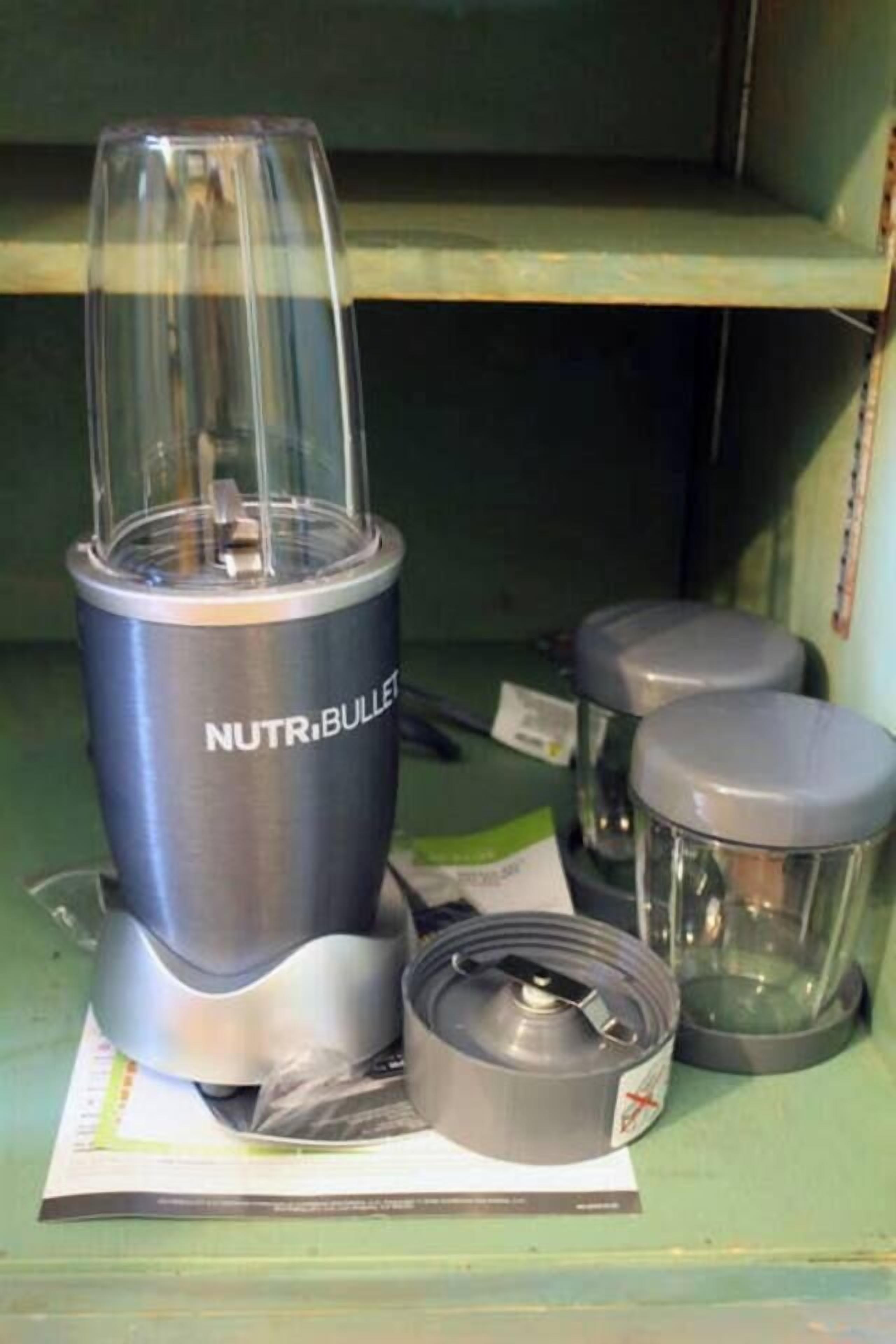 A kitchen area with a blender, two containers, and a blender jar on a green countertop.