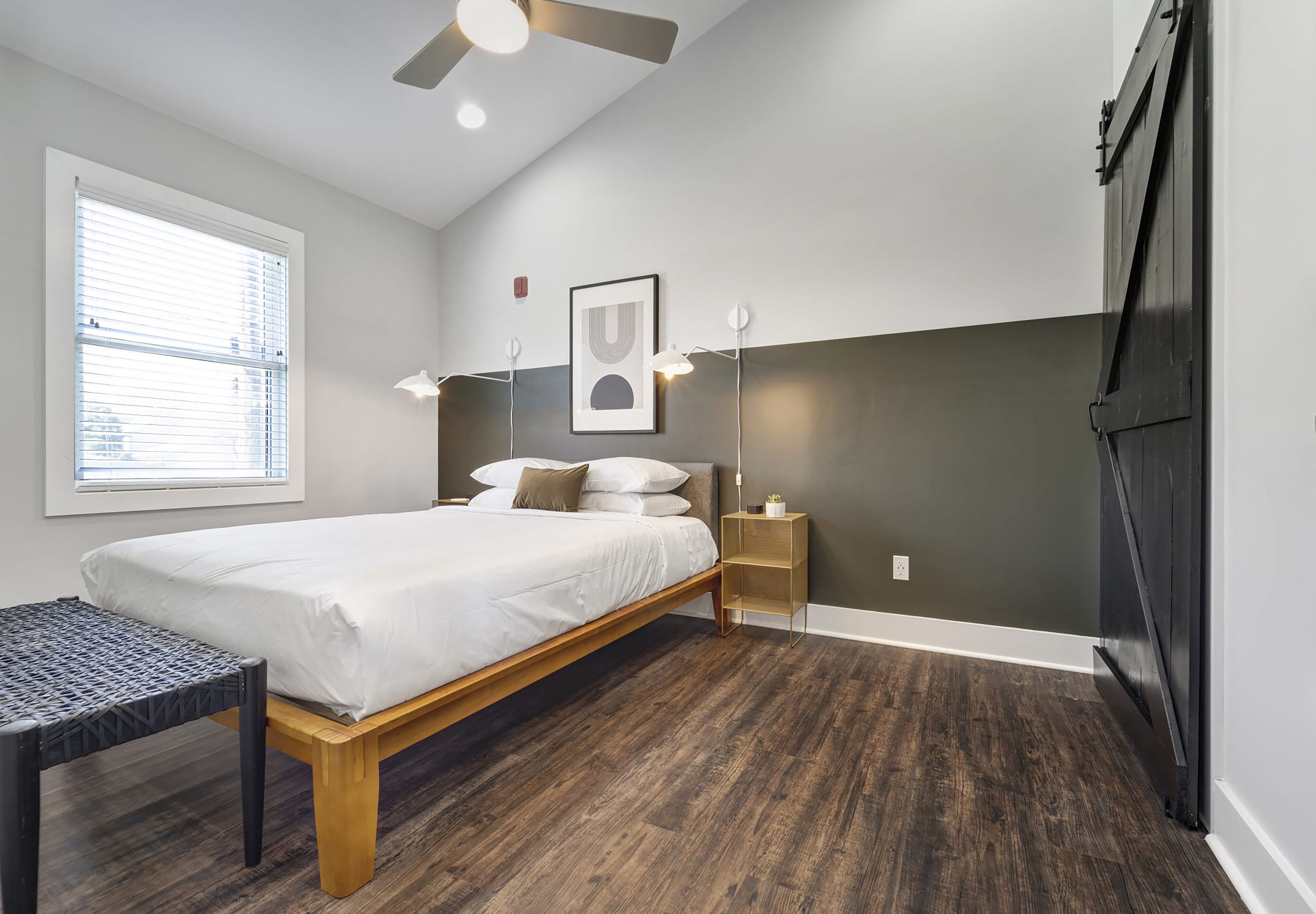 Un dormitorio con cama, mesita de noche, lámpara y ventilador de techo.