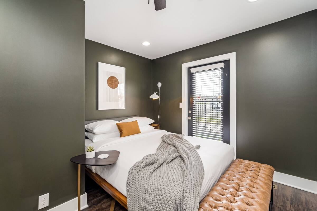 A bedroom with a bed, bedside table, and a bench.