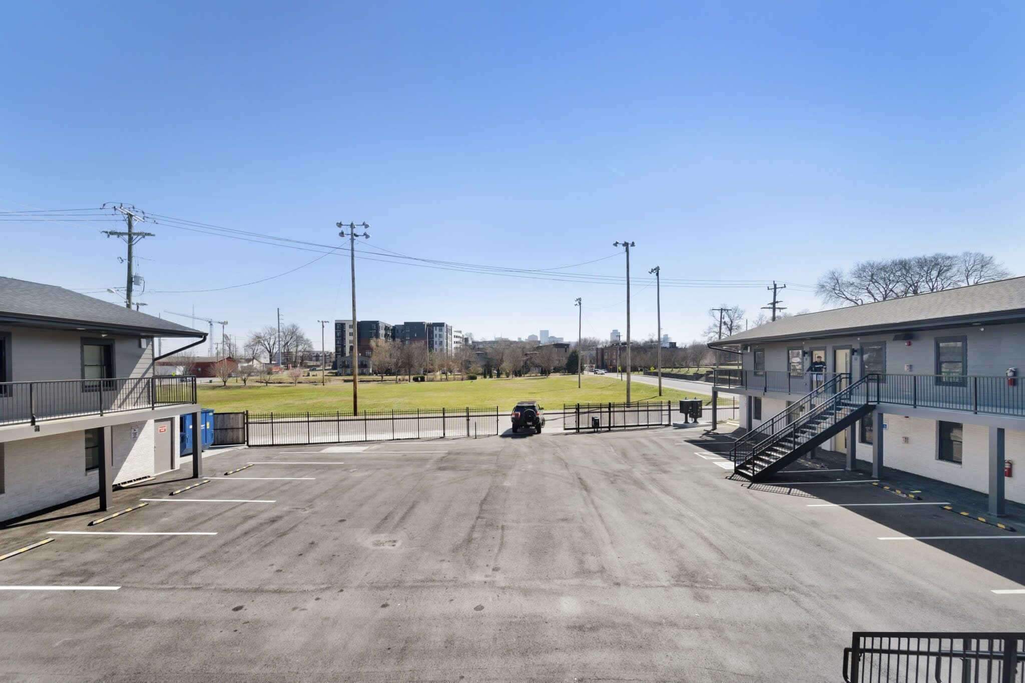 A parking lot with a building on the left and a staircase on the right.