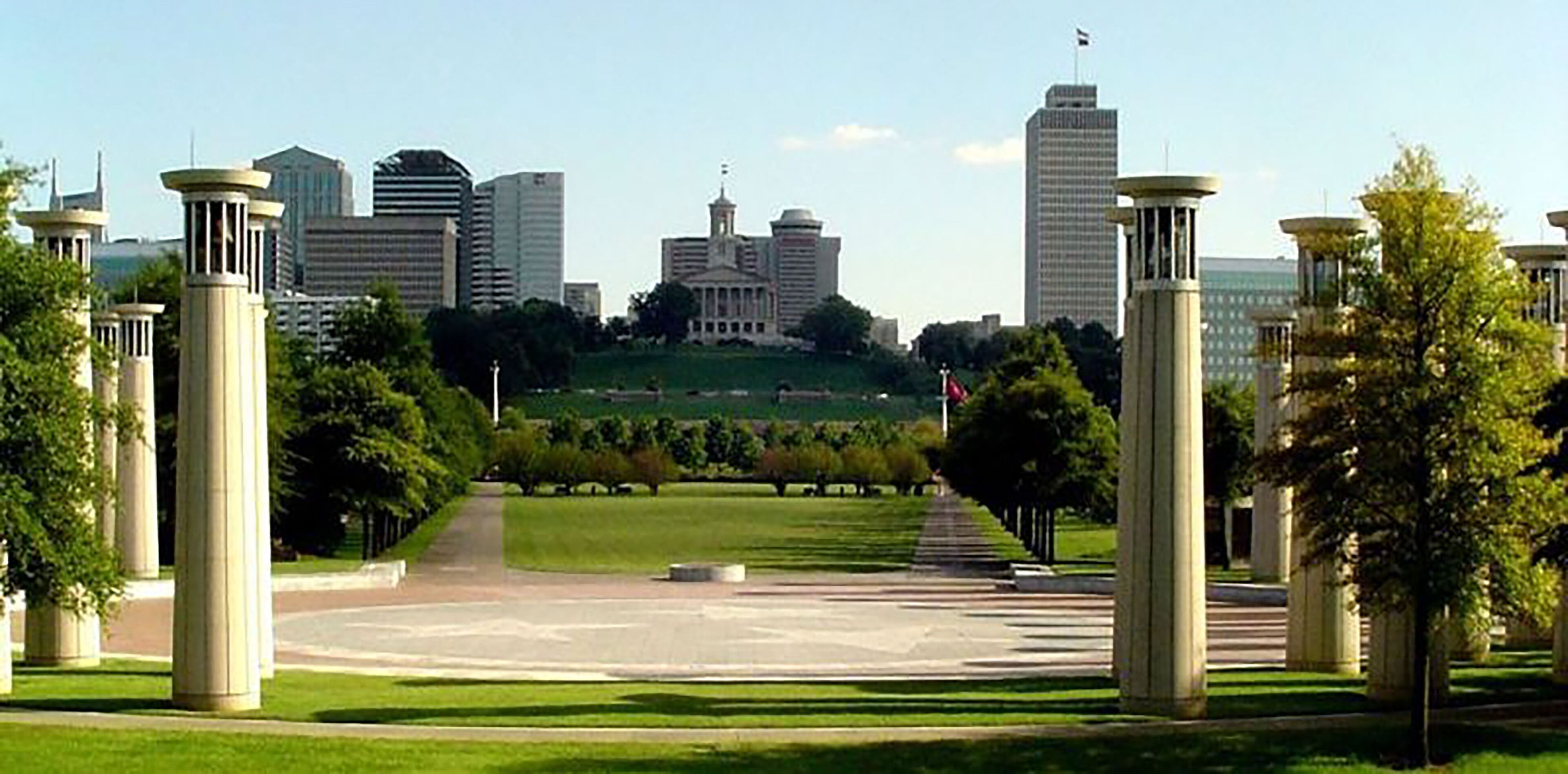 A cityscape with a prominent building in the center, surrounded by modern high-rise buildings.
