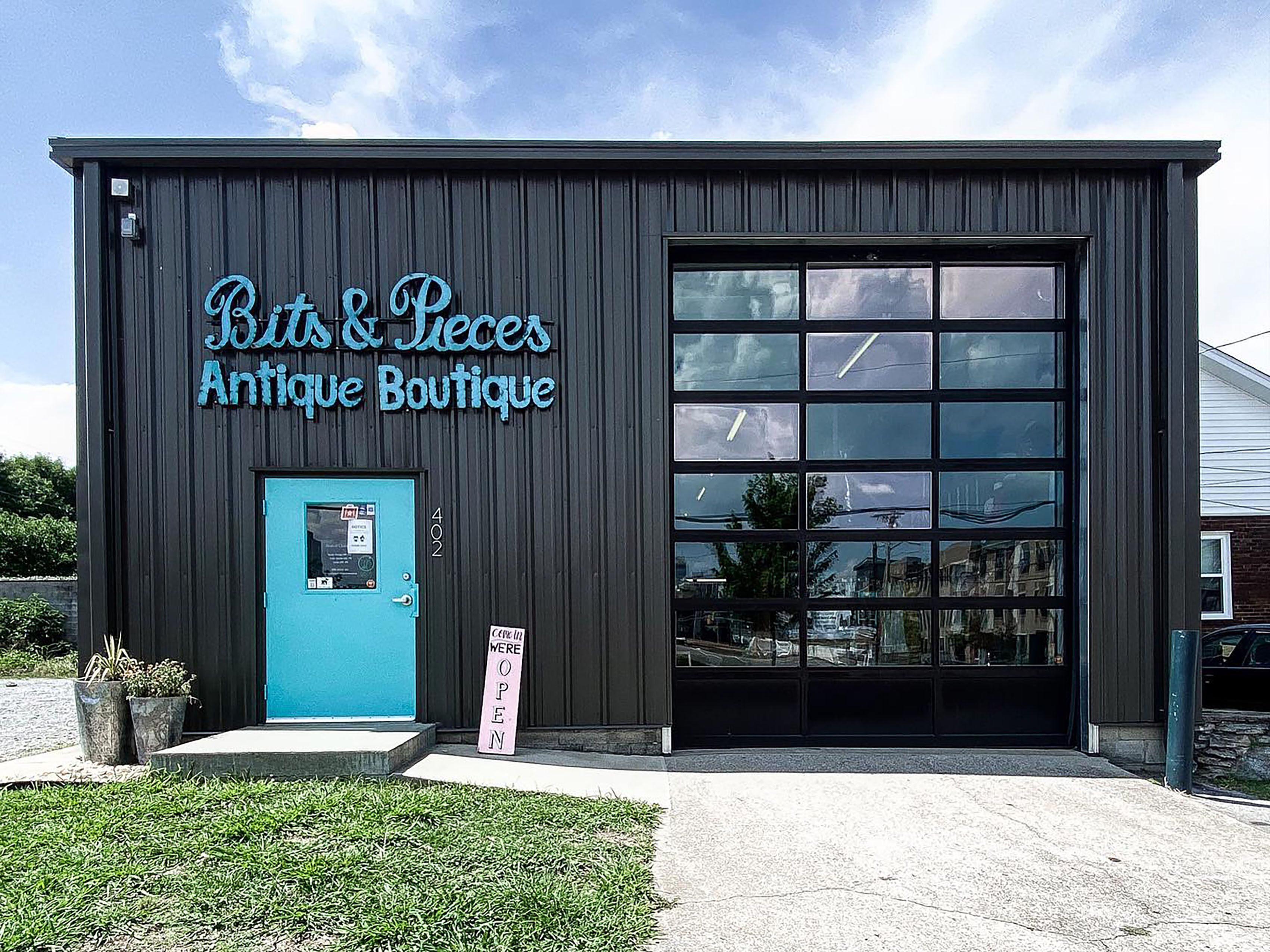 A building with a sign reading "Bits & Pieces Antique Boutique" and a blue door.