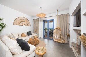 A modern living room with a sofa, coffee table, and a hanging chair. - Villa Canova - Three Bedroom Villa, Sleeps 6 (Ionian Islands)