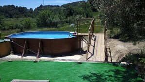 Une piscine avec une terrasse en bois et un plongeoir.