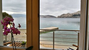 A view from a balcony overlooking a lake with mountains in the distance. - Holiday apartment with balcony and sea view (Baška)