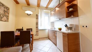 Una cucina funzionale con mobili in legno, un tavolo da pranzo con sedie e una finestra con tende.