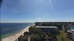 A coastal view with a beach, buildings, and a clear sky.