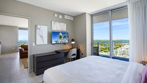 Een moderne hotelkamer met een groot bed, een bureau en uitzicht op de stad.