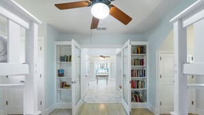 A hallway with open bookcases, a ceiling fan, and a marble floor. - Only 361 Feet to Beach Access in Seaside, King Primary & Renovated + 2 Bikes (Santa Rosa Beach Fl)