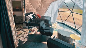 A tented room with a bed, chairs, a table, and a ceiling fan. - Dome 3: Modern Boho Hideaway (South Haven)