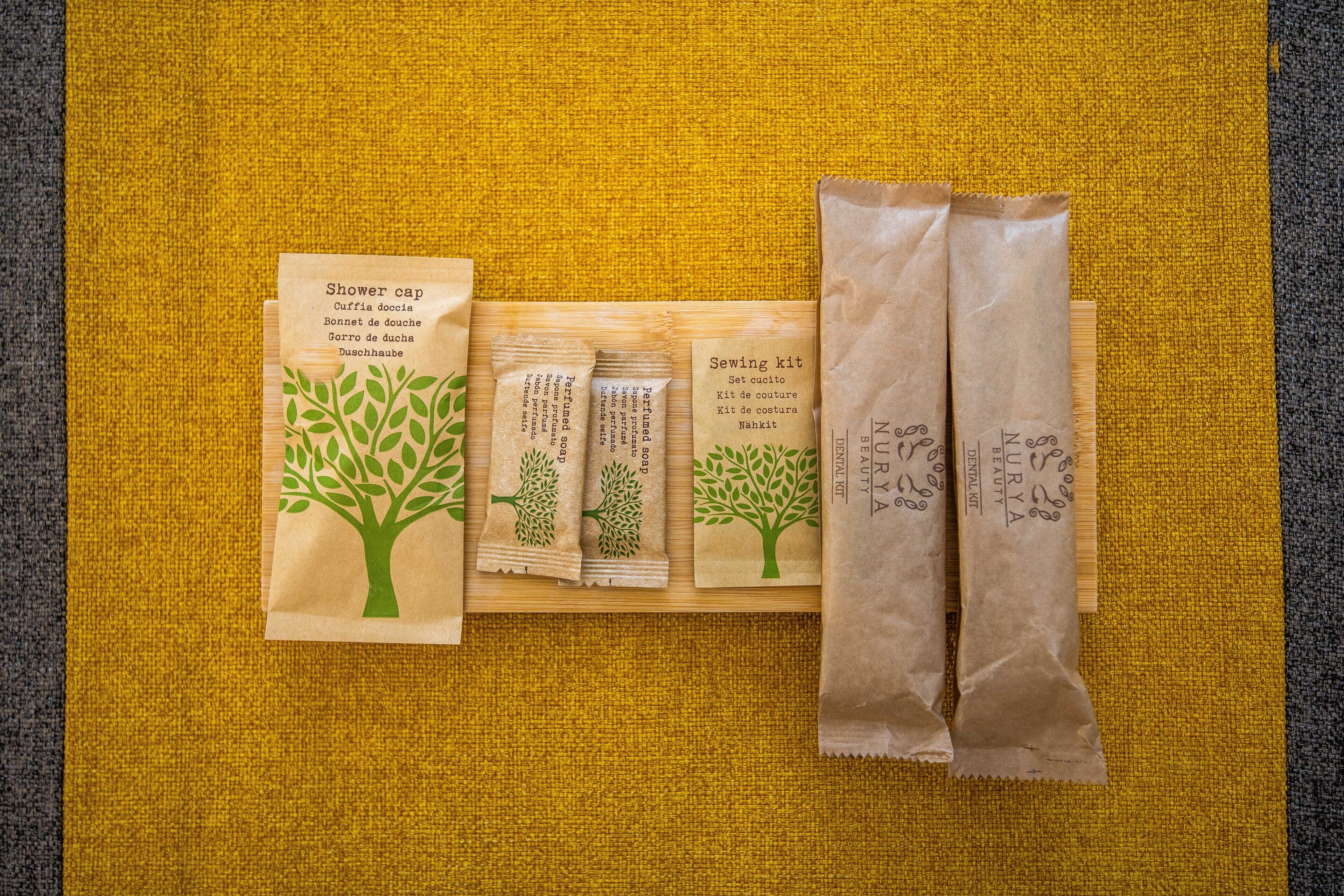 Une surface en bois sur laquelle se trouvent quatre objets : un bonnet de douche, une trousse à couture et deux paquets de tissu.