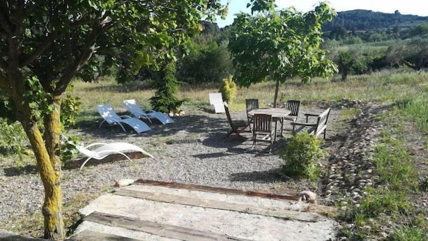 A patio area with outdoor seating and a wooden deck. - Mas Guilló Nursery (Sant Quintí de Mediona)