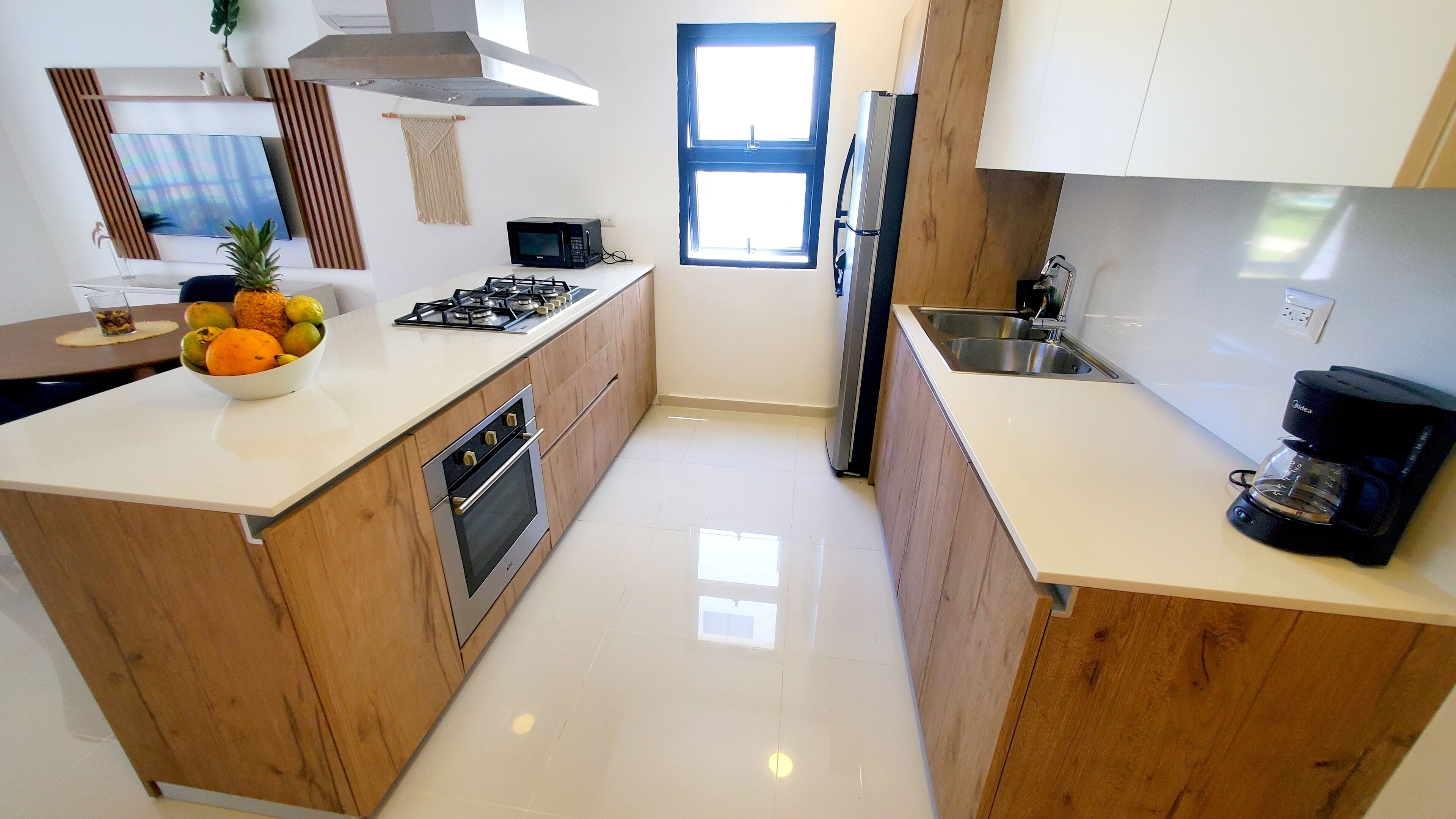 A modern kitchen with wooden cabinets, a gas stove, a microwave, and a coffee maker.