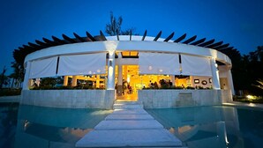 A circular building with a covered entrance and a pool in front. - Amar'e Aparthotel & Spa (Las Terrenas)