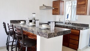 A kitchen with a granite countertop, a built-in stove, and wooden cabinets.