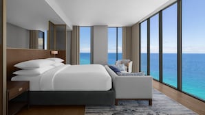 A modern hotel room with a large bed, a seating area, and a view of the ocean. - Sheraton Cebu Mactan Resort (Lapu-Lapu)
