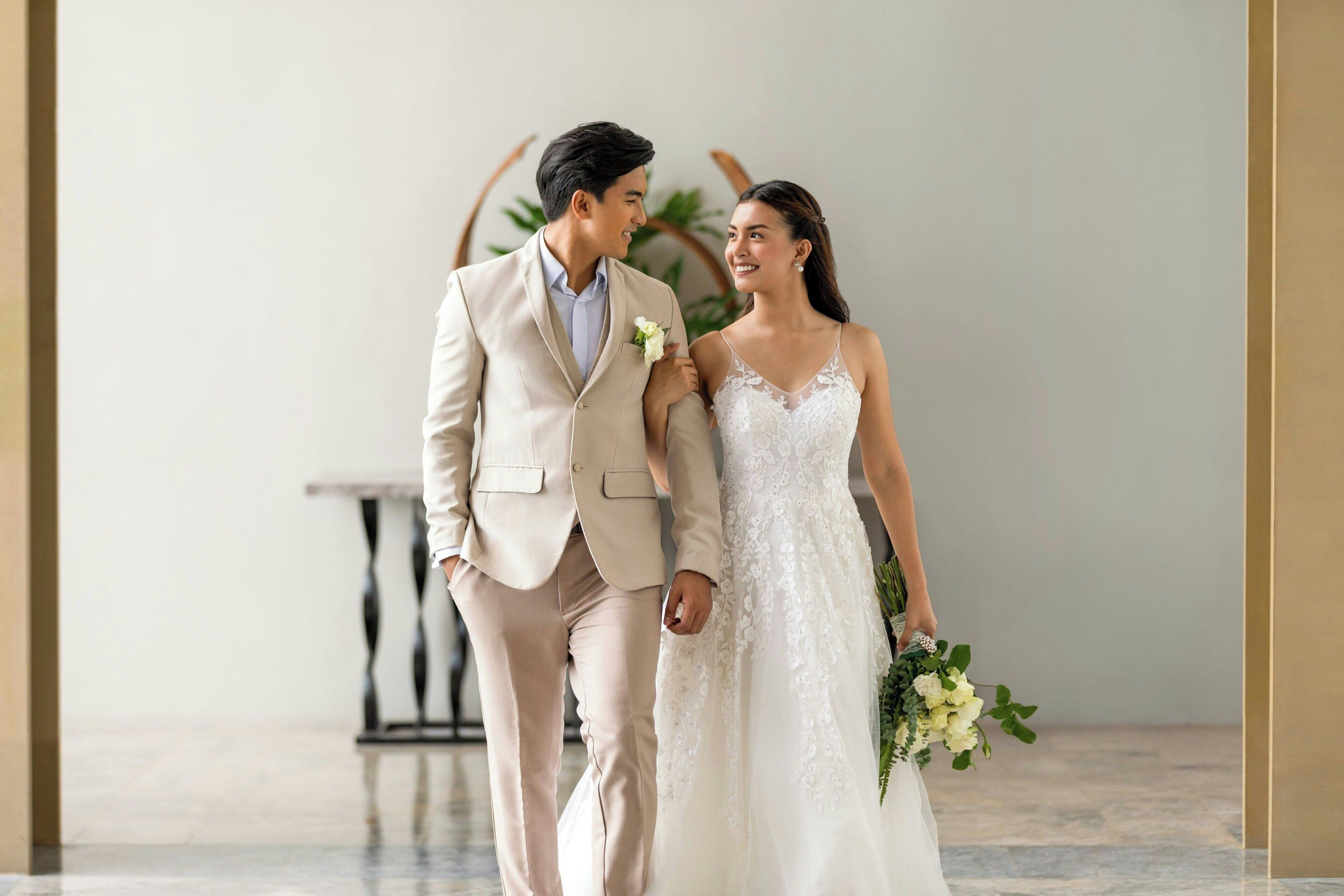 A couple in wedding attire walking together.
