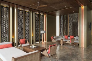 Un salón moderno con un sofá, sillones y una mesa de centro.