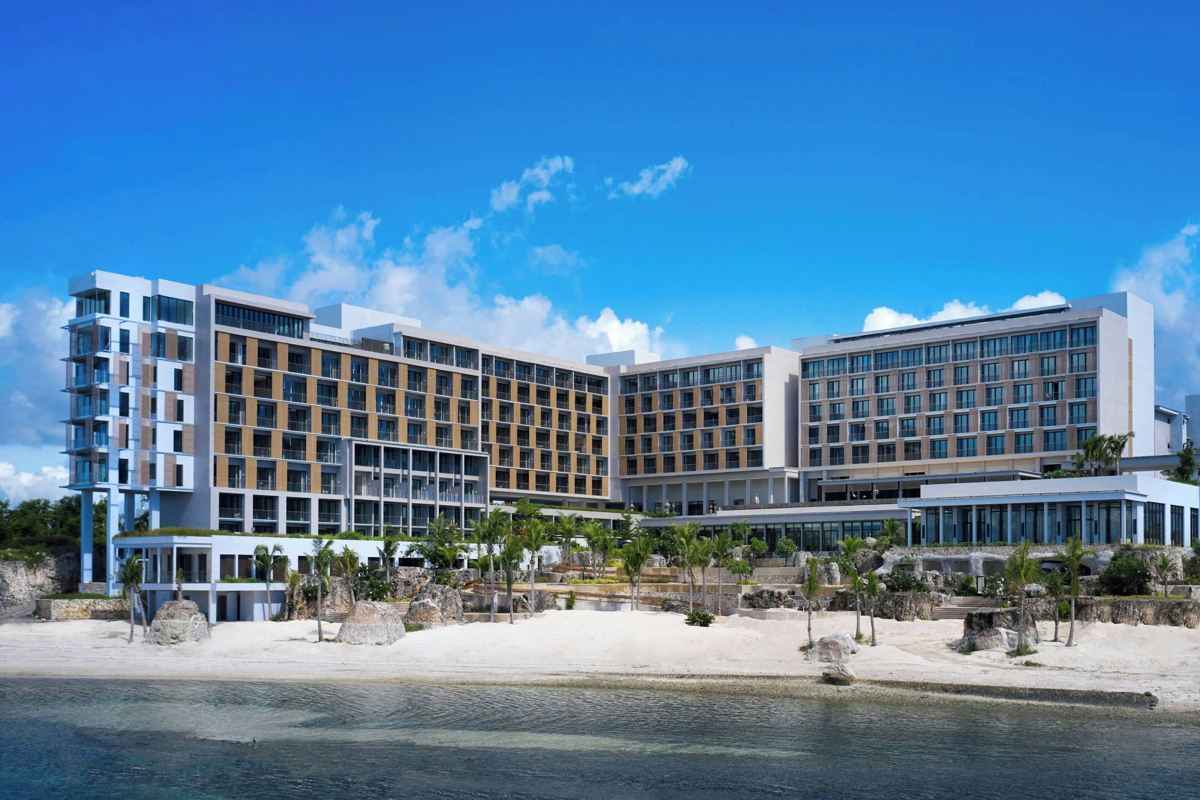 Un hotel moderno con diverse facciate, ampie finestre e posizione fronte mare.