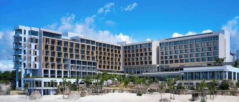 Un hotel moderno con diverse facciate, ampie finestre e posizione fronte mare.