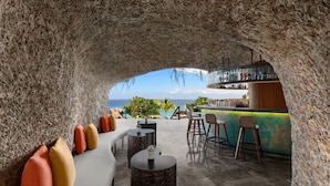 A bar area with a stone archway, seating, and a view of the ocean. - Sheraton Cebu Mactan Resort (Lapu-Lapu)