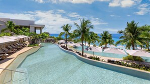 A resort pool with clear water, surrounded by palm trees and lounge chairs. - Sheraton Cebu Mactan Resort (Lapu-Lapu)