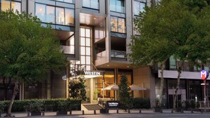 Un hôtel moderne, reconnaissable à son grand panneau « WESTIN », doté d’une terrasse et d’une façade bien entretenue.