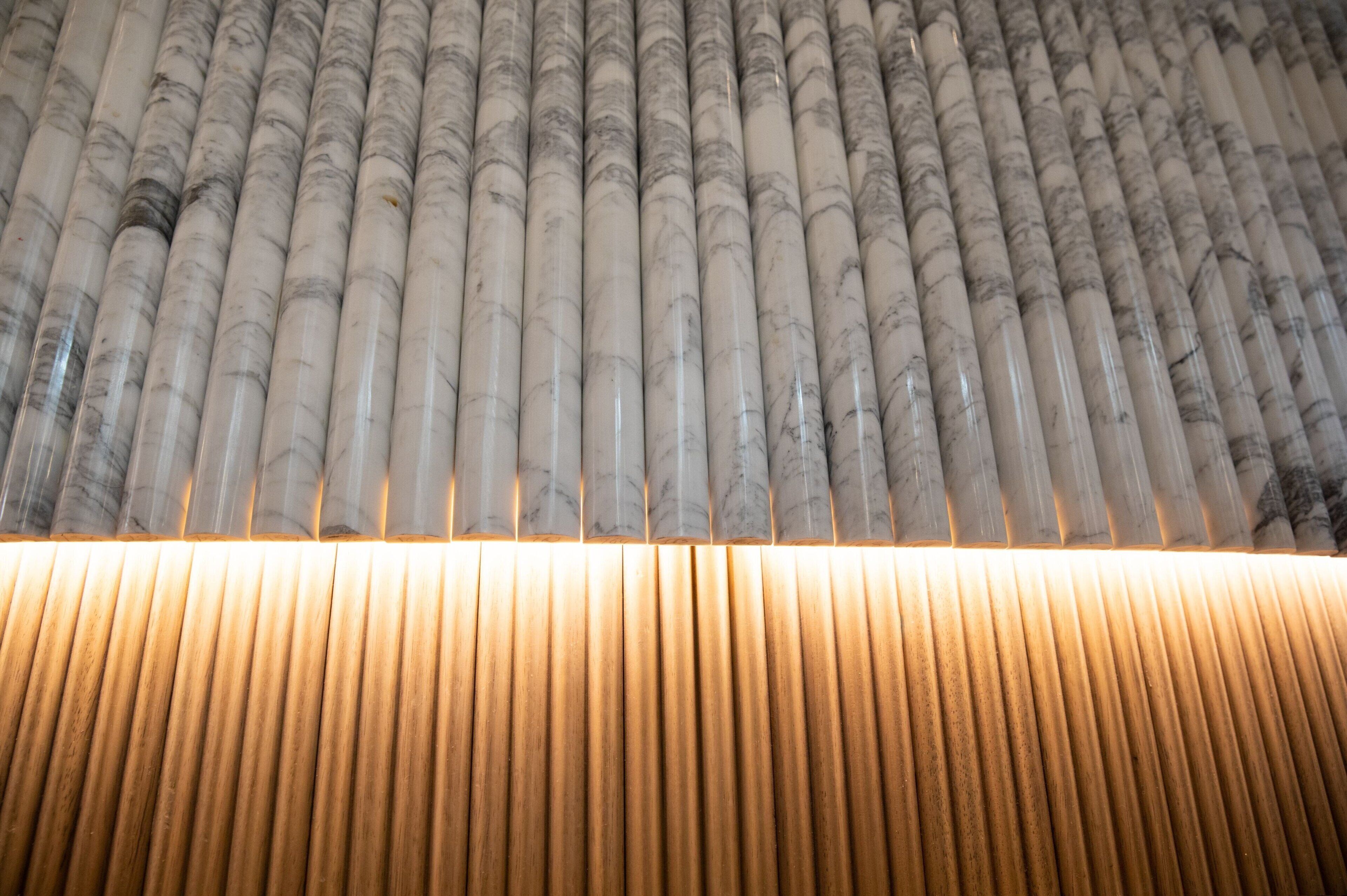 Una hilera de columnas cilíndricas con suelo de tablones de madera.