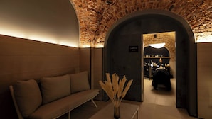 A modern interior with a brick ceiling, a sofa, a table with a vase, and an arched doorway leading to a room labeled "GARDIN 2". - Hotel Verte, Warsaw, Autograph Collection (Warsaw)