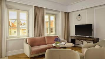 A living room with a sofa, armchairs, a coffee table, and a TV.