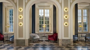 A room with a checkered floor, three large windows with curtains, and a chandelier. - Hotel Verte, Warsaw, Autograph Collection (Warsaw)