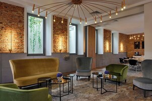 Una sala d'attesa moderna con pareti in mattoni, ampie finestre e arredamento contemporaneo.