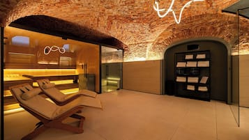 Un área de spa con techo de ladrillo, una silla de masaje y una mesa de recepción.