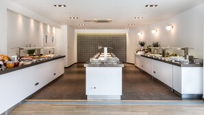 Cocina moderna y luminosa con una isla central, equipada con diversos electrodomésticos y un sistema tipo bufé.