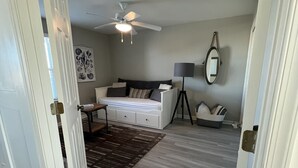A bedroom with a bed, a ceiling fan, a floor lamp, and a rug. - Large 4 bedroom penthouse unit 5 miles from Bethany Beach (Ocean View)