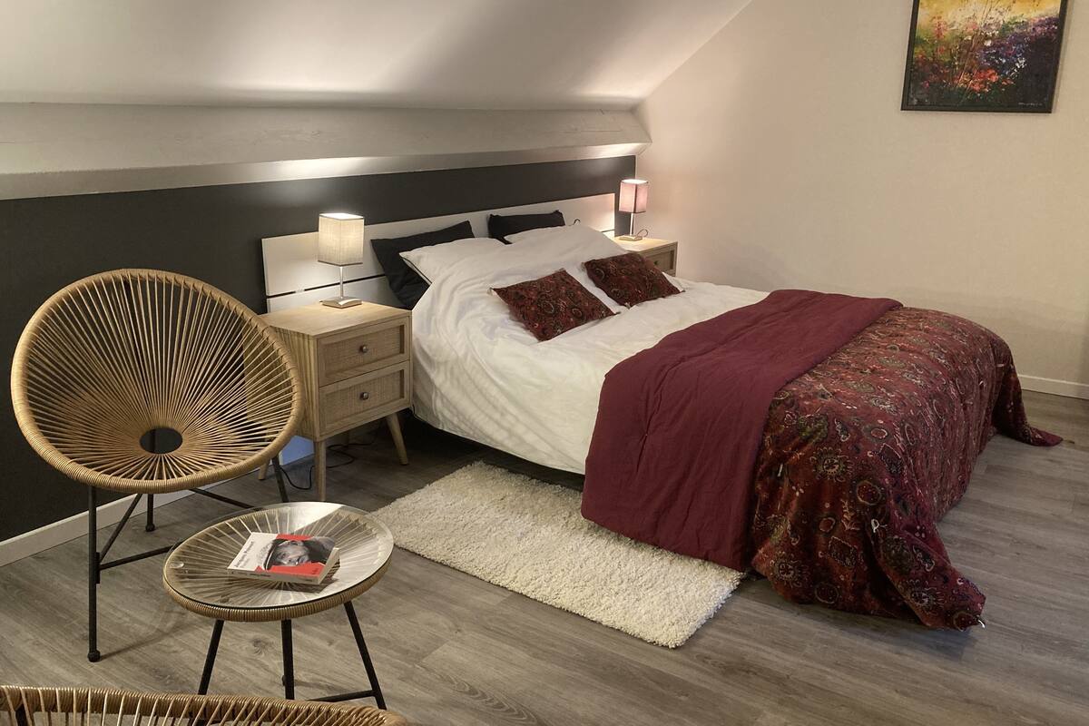 A modern bedroom with a bed, nightstands, a chair, and a rug.