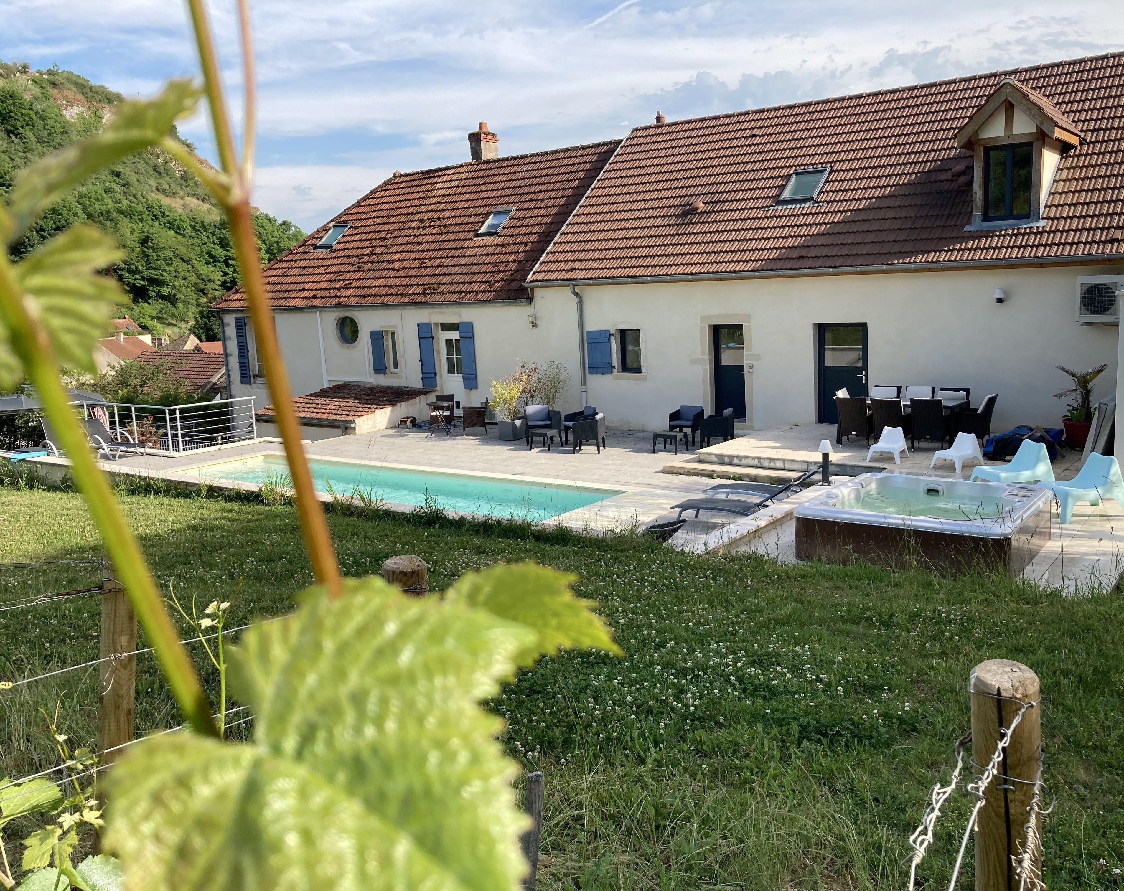 Een huis met een zwembad, terras en tuin.