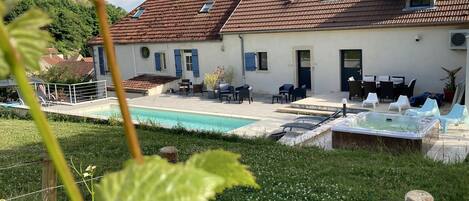 A house with a swimming pool, outdoor seating, and a garden.