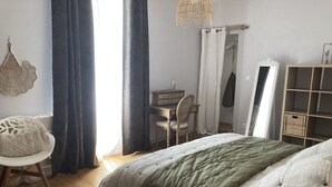 Un dormitorio con cama, escritorio, silla y armario.