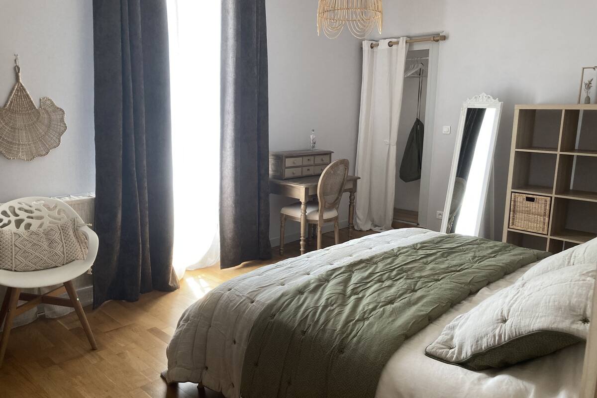 A bedroom with a bed, a desk, a chair, and a wardrobe.