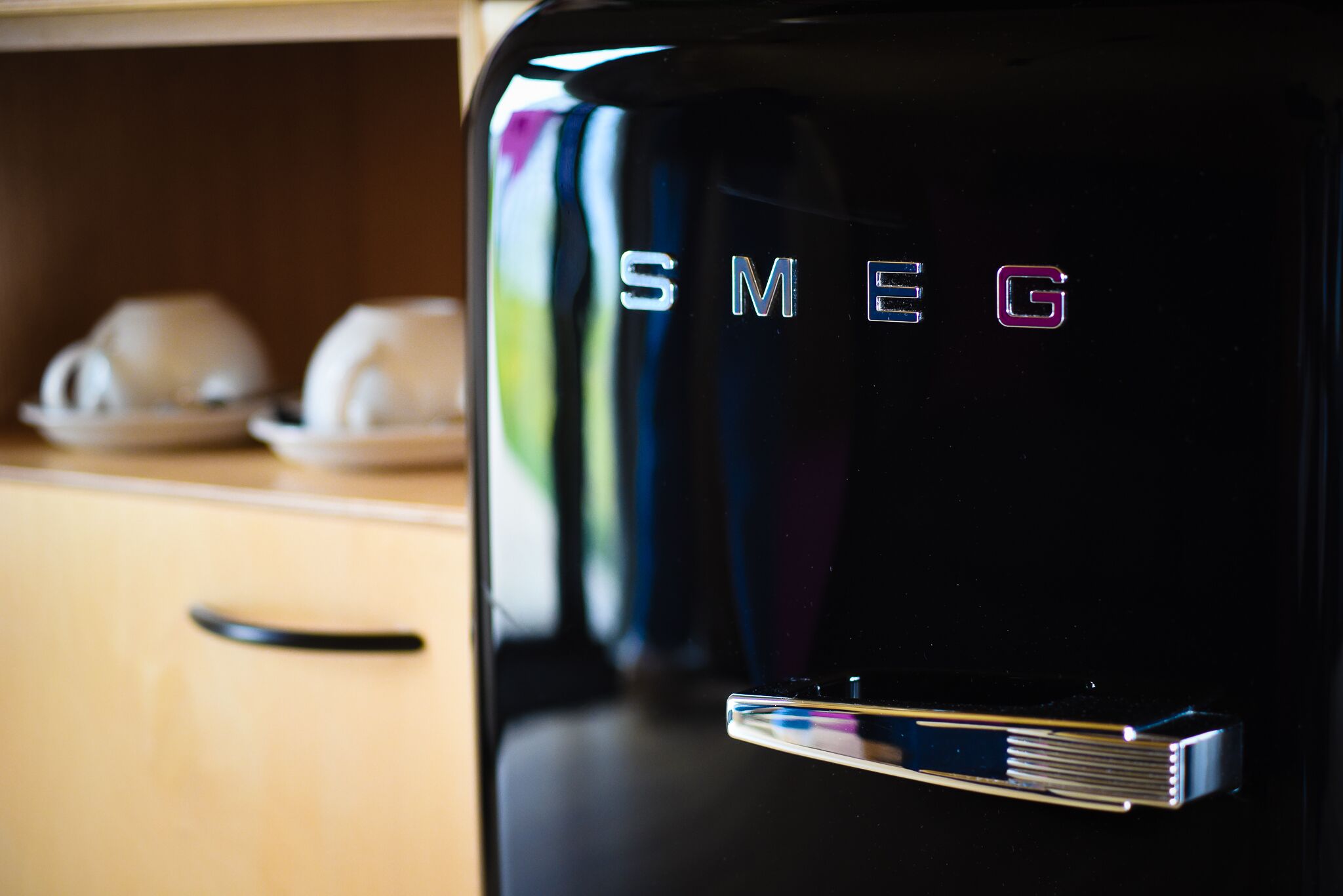 Uma cafeteira de café expresso preta, com a marca 'SMEG'.