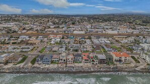 An aerial view of a coastal residential area with houses, a beach, and a highway. - Oceanside Beach Rental - Walk to the Boardwalk! (Oceanside)