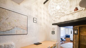 Un comedor con una mesa y sillas de madera, un mapa en la pared y una lámpara decorativa.